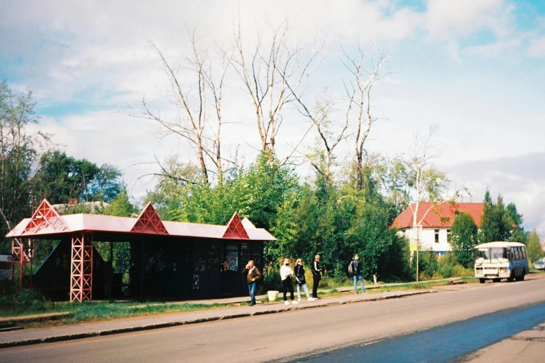 a bus stop sitting on the side of a road, by Attila Meszlenyi, danube school, 2000s photo, people walking, preserved historical, nadezhda tikhomirova