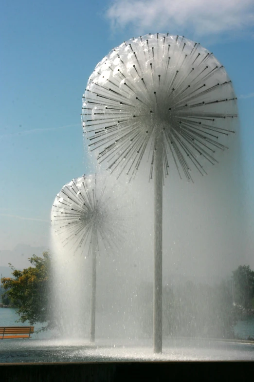 a fountain with water spewing out of it, inspired by Otto Piene, kinetic art, dandelions, chile, the three suns, closeup - view