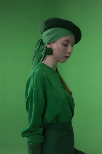 a woman in a green dress and hat, inspired by Art Green, trending on pexels, solid color backdrop, berets, issey miyake, hana alisa omer