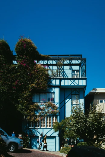 a blue building sitting on the side of a road, a colorized photo, inspired by Ricardo Bofill, unsplash, art nouveau, beachwood treehouse, exterior botanical garden, chile, sunny bay window