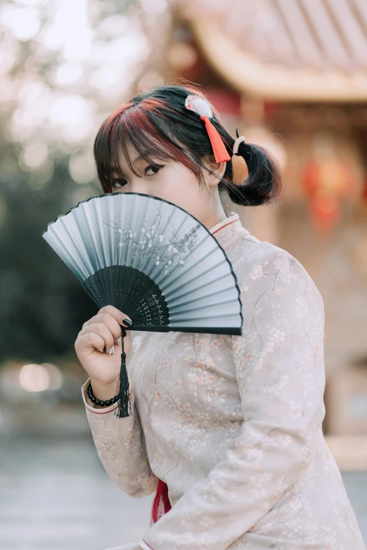 a woman sitting on a bench holding a fan, inspired by Fan Qi, pexels contest winner, realism, japanese streetwear, hanfu, profile pic, warm friendly face