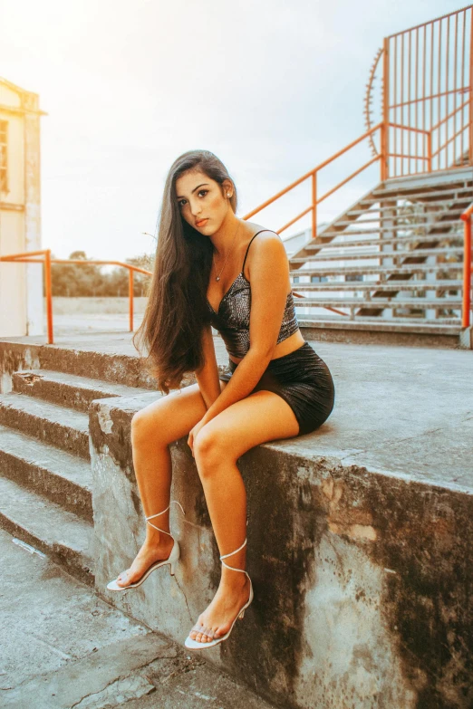 a woman sitting on the steps of a building, bra and shorts streetwear, with long dark hair, 5 0 0 px models, trending arstationhq