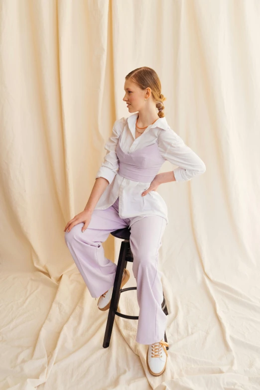 a woman sitting on top of a stool, white and purple, tailored clothing, pastel hues, emma