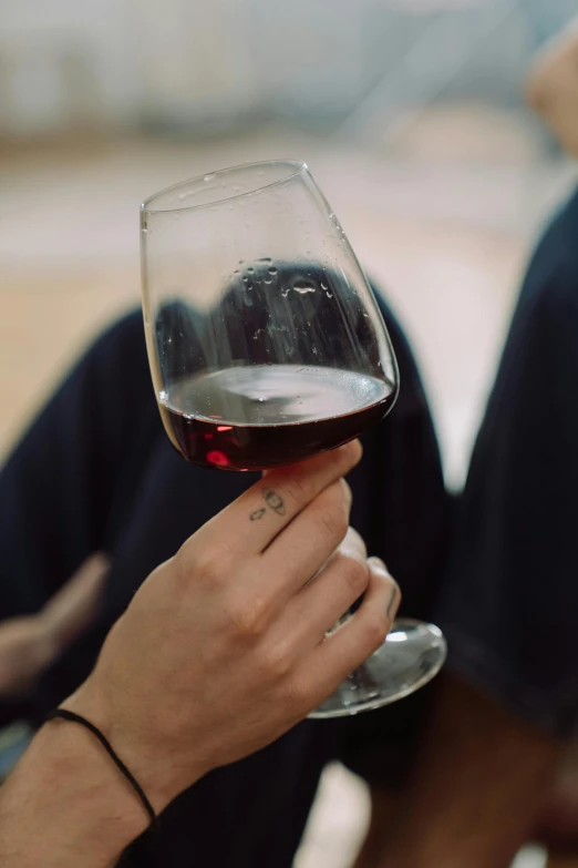 a close up of a person holding a glass of wine, slightly red, wine, sitting down, highly upvoted