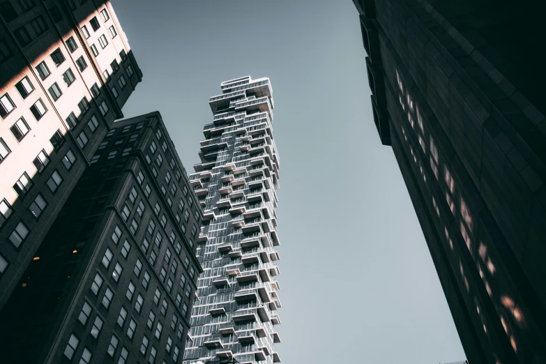 a tall building in the middle of a city, unsplash contest winner, brutalism, ignant, shot from the side, new york in the future, interesting angle