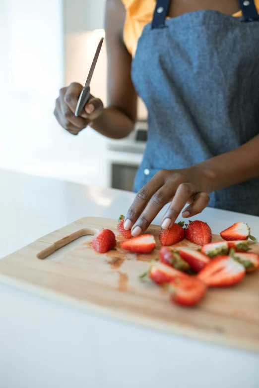 a woman cutting strawberries on a cutting board, pexels contest winner, essence, smooth contours, detailing, single figure