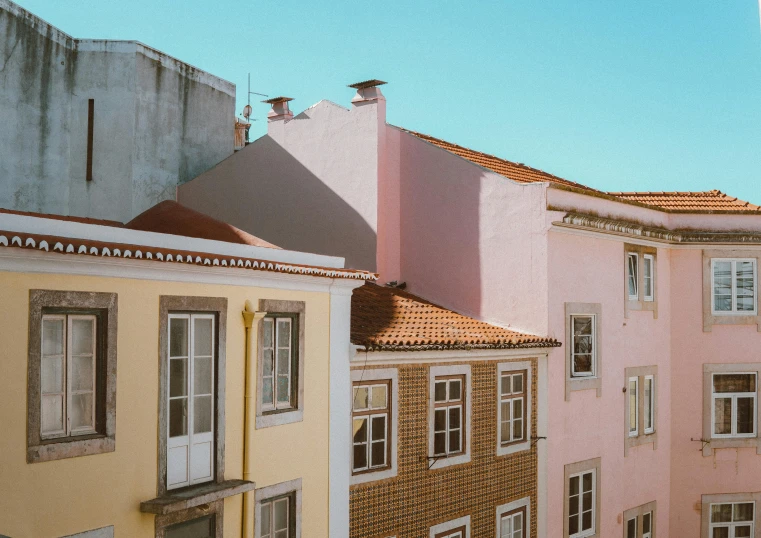 a couple of buildings that are next to each other, pexels contest winner, neoclassicism, pastel pink skin tone, portugal, profile image, roofs