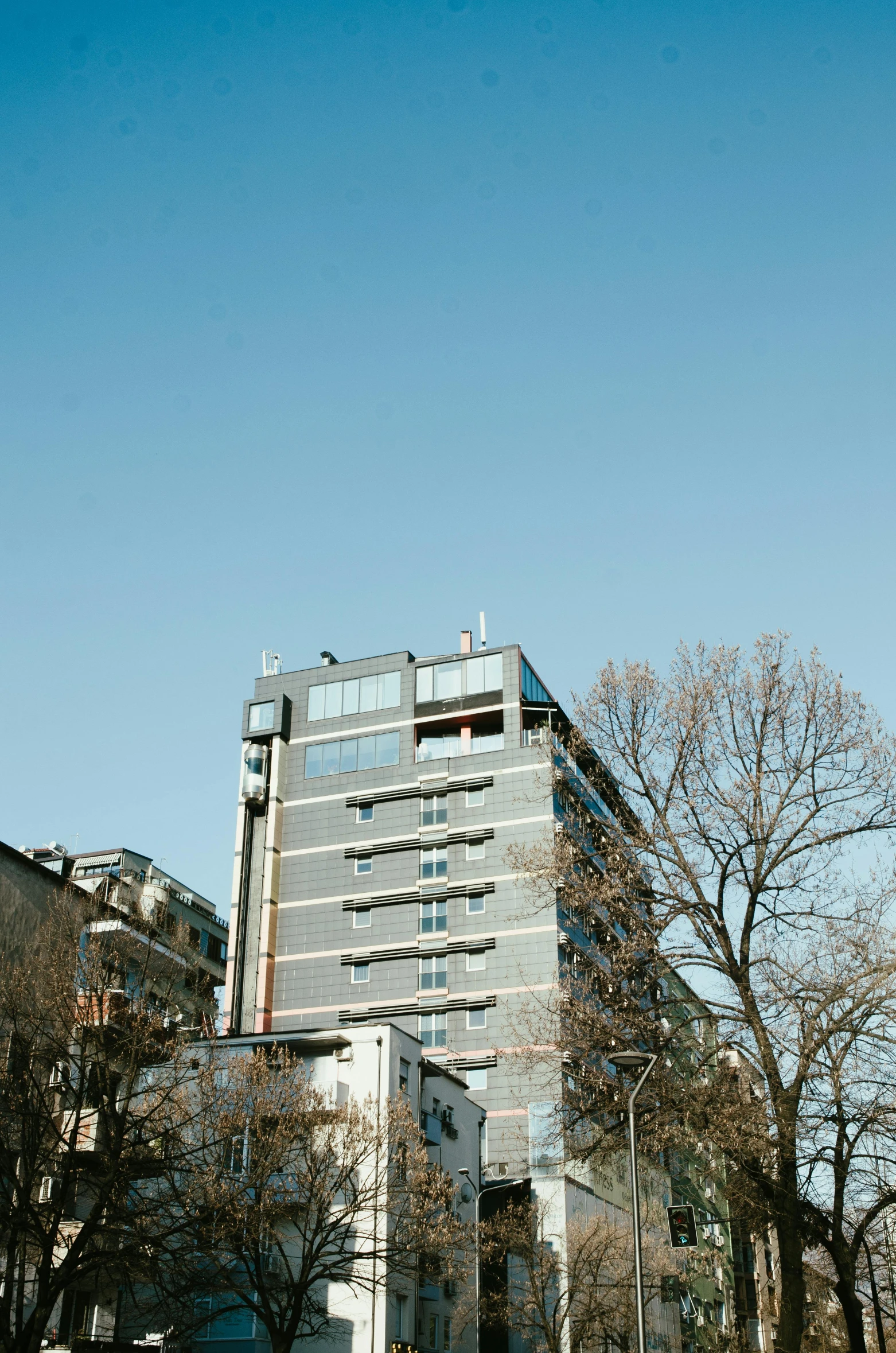 a red fire hydrant sitting on the side of a road, by Sven Erixson, unsplash, modernism, soviet apartment building, panorama view, clear blue sky, swiss architecture