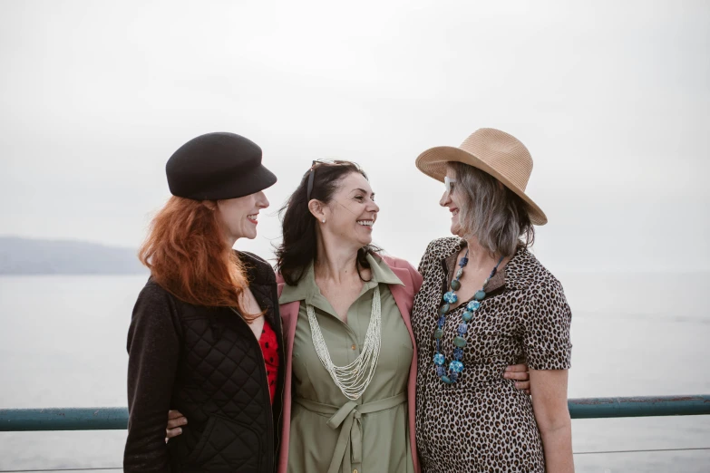 a group of three women standing next to each other, a portrait, unsplash, with hat, seaview, avatar image, middle aged