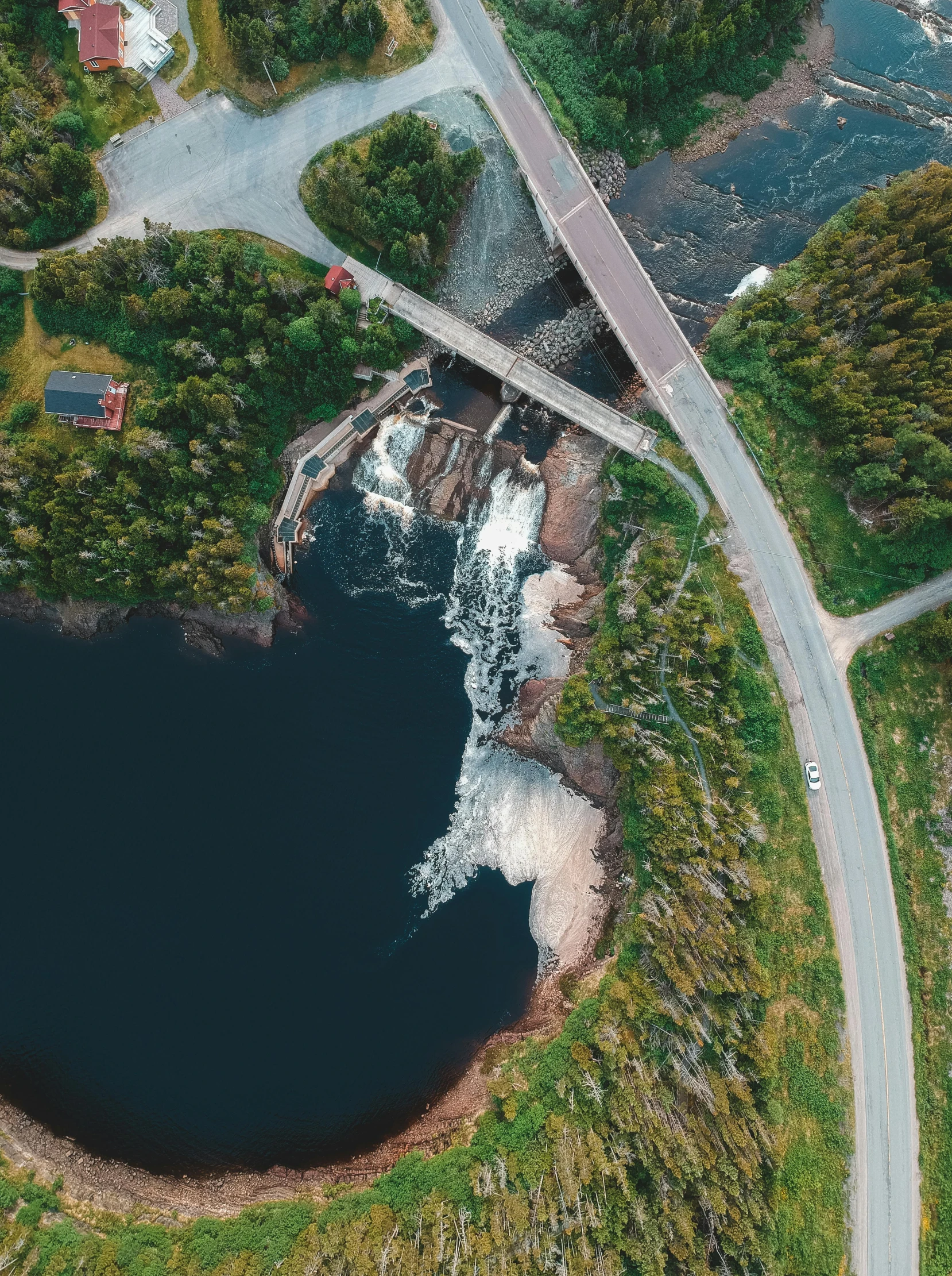 an aerial view of a large body of water, by Roar Kjernstad, pexels contest winner, hurufiyya, water fall, pewdiepie selfie at a bridge, thumbnail, quebec