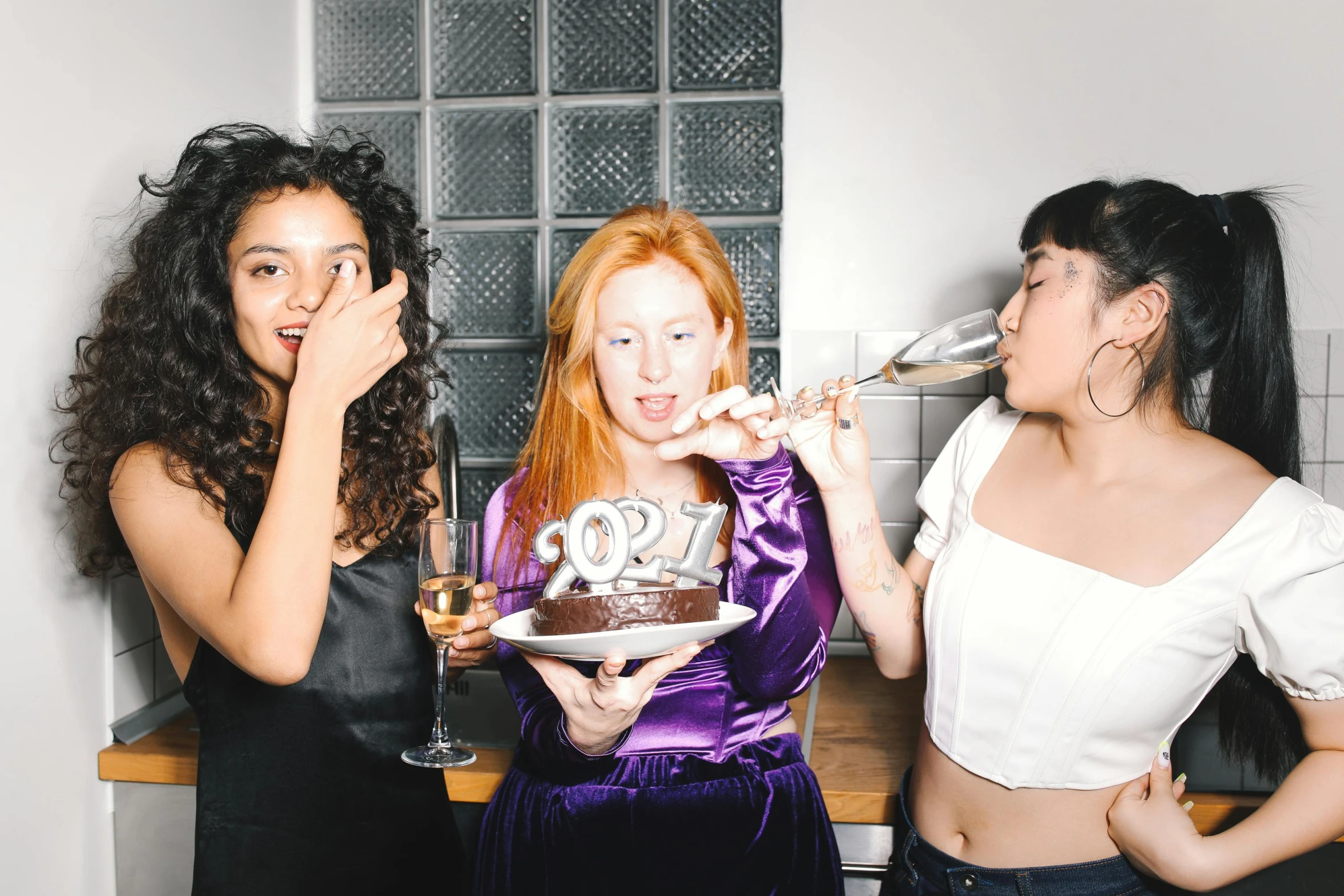 a group of women standing next to each other eating cake, an album cover, trending on pexels, new years eve, charli bowater, revellers, magazine photo