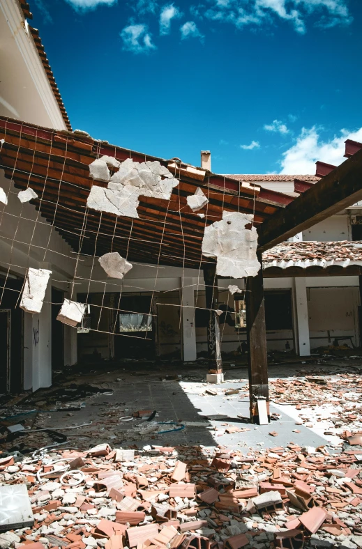 a building that has a bunch of papers hanging from it, an album cover, unsplash, earthquake destruction, school courtyard, damaged photo, background image