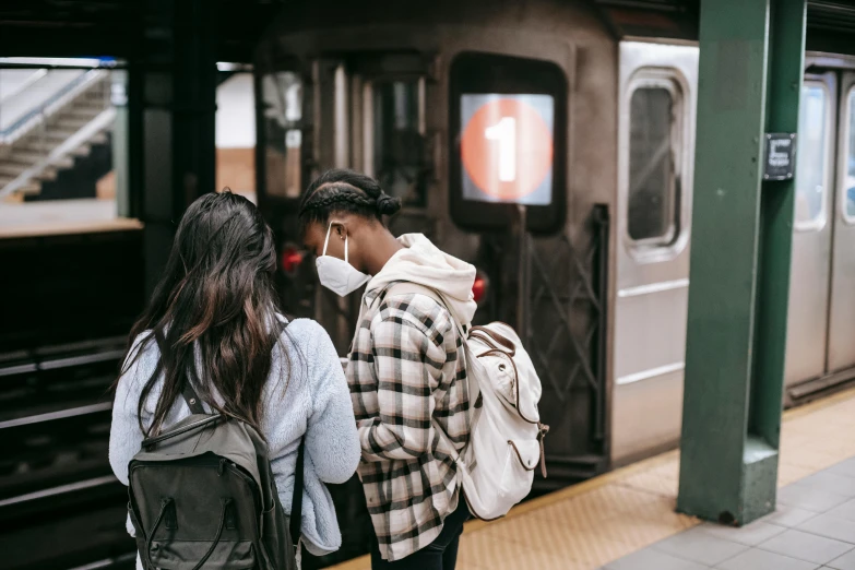 a couple of people that are standing in front of a train, trending on unsplash, partially masked, nyc, 😭🤮 💔, teenage girl