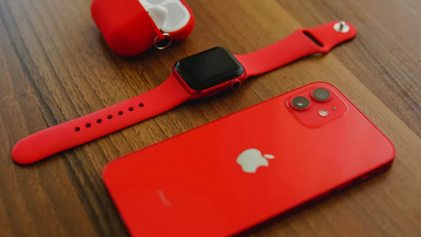 a red apple watch sitting on top of a wooden table, trending on pexels, airpods, wearing a red outfit, cell phone, monochromatic