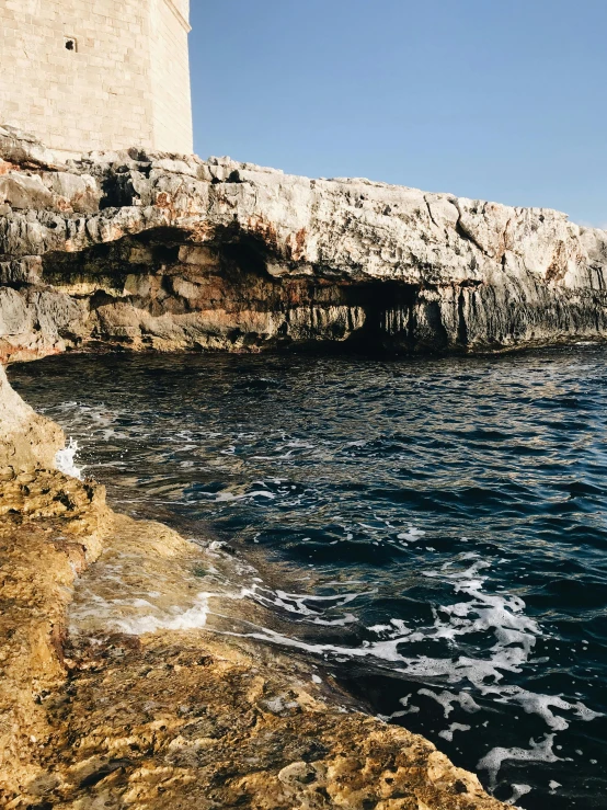 a lighthouse sitting on top of a cliff next to the ocean, inspired by Fede Galizia, les nabis, natural cave wall, slide show, julia sarda, croatian coastline