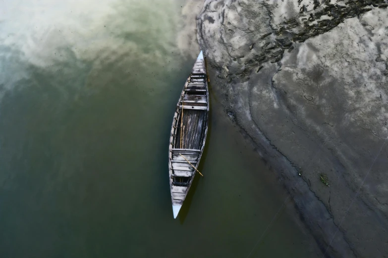 a small boat sitting on top of a body of water, by Andries Stock, pexels contest winner, hurufiyya, assamese aesthetic, high - angle view, ash thorp, broken composition