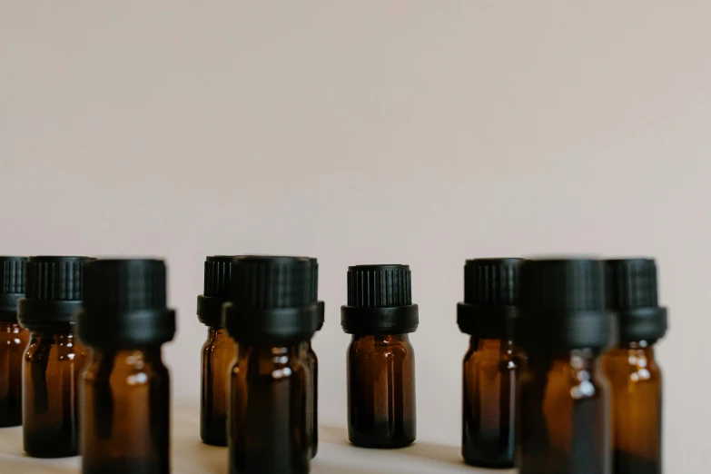 a row of brown bottles sitting on top of a counter, trending on pexels, visual art, vials, manuka, background image, botanicals