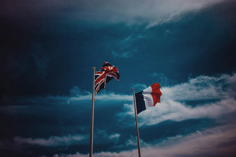 two flags flying next to each other under a cloudy sky, by Romain brook, pexels, french, 🚿🗝📝, brown red blue, dark and white