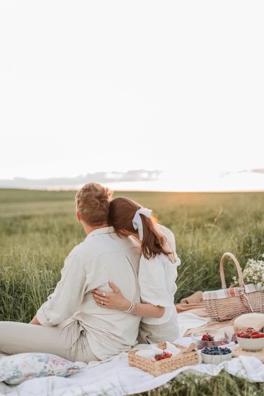 a man and woman sitting on a blanket in a field, pexels contest winner, romanticism, over his shoulder, white, fine dining, soft glow