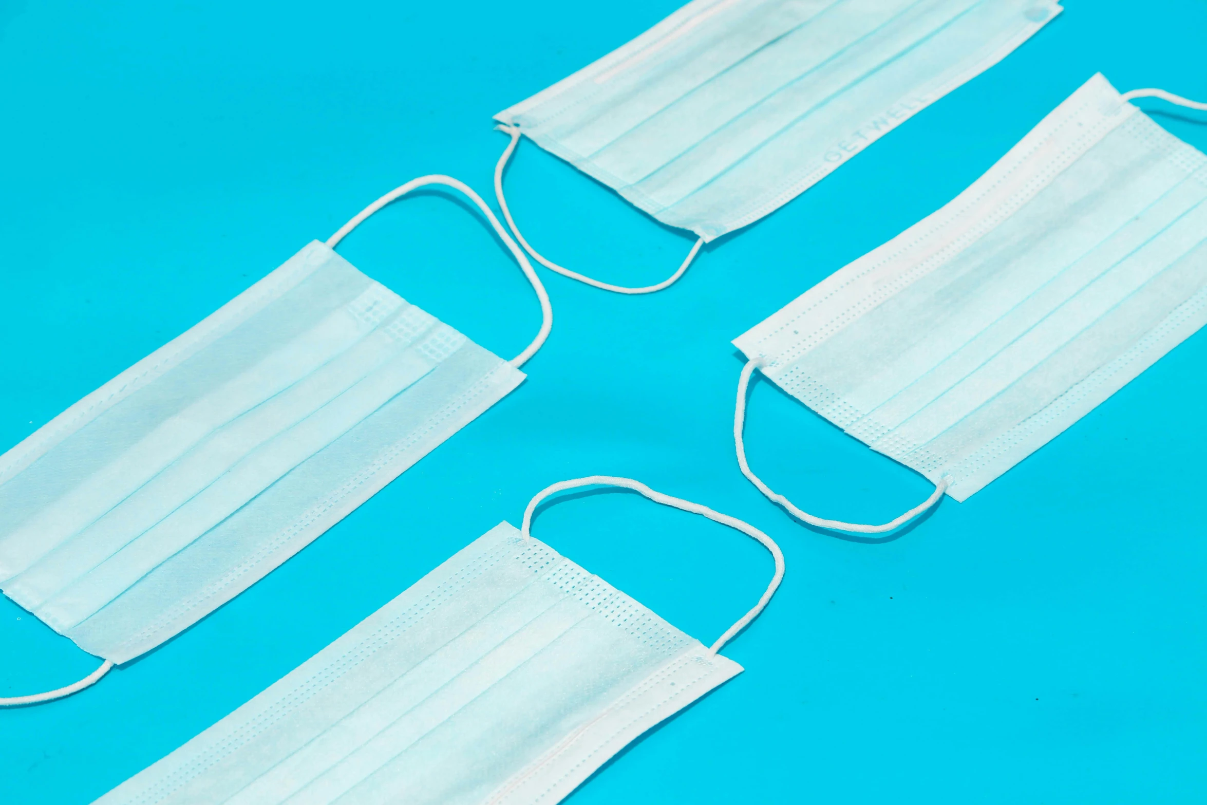 three surgical masks on a blue background, by Rachel Reckitt, trending on pexels, plasticien, white cummerbund, in a row, detailed product image, white