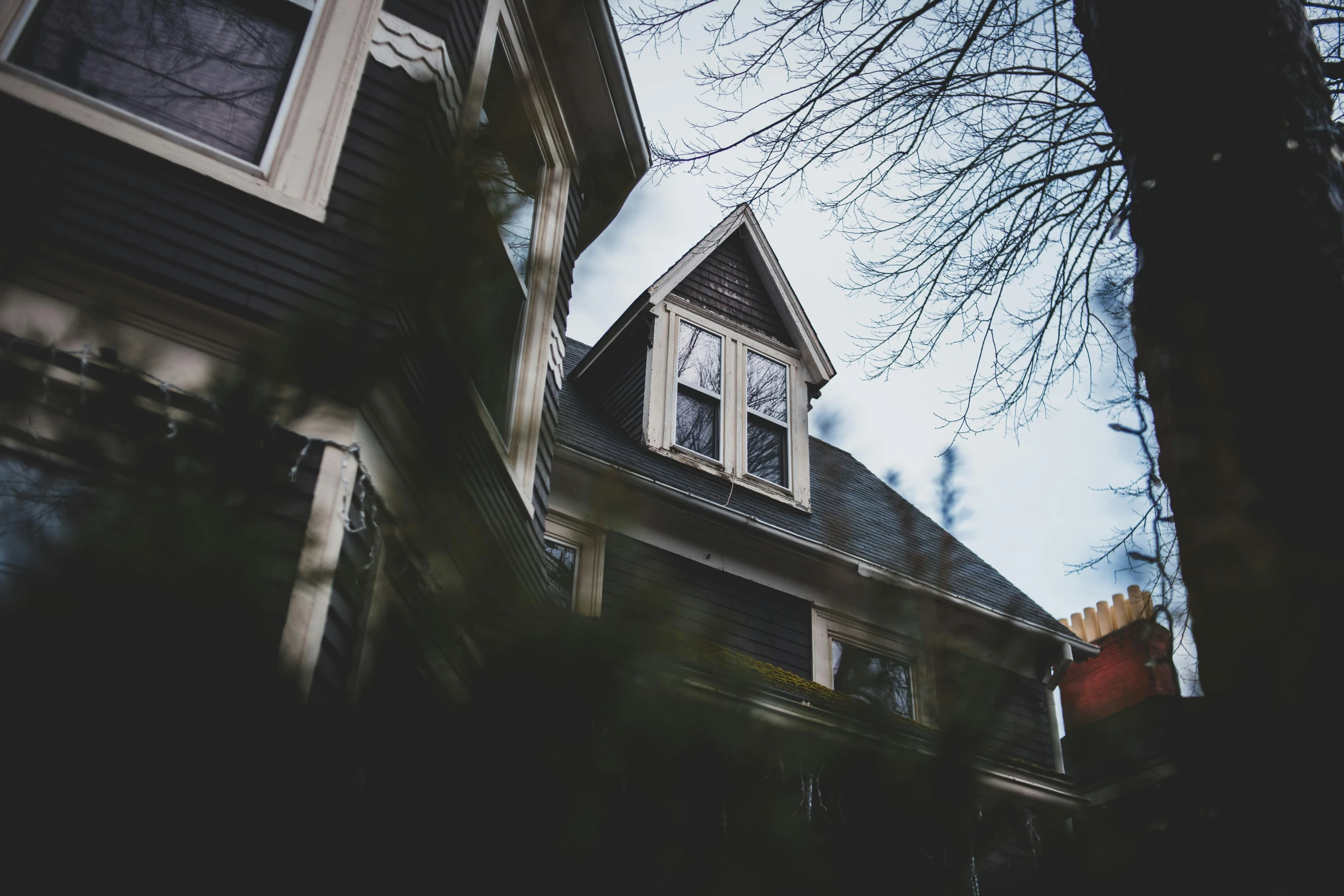 a black and white photo of a house, a photo, by Carey Morris, pexels contest winner, magical realism, moody muted colors, victorian house, low angle photograph, background image