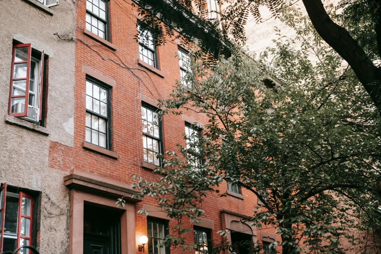 a red fire hydrant sitting in front of a brick building, by Nina Hamnett, pexels, art nouveau, massive trees with warm windows, new york back street, 1792, people looking at a house