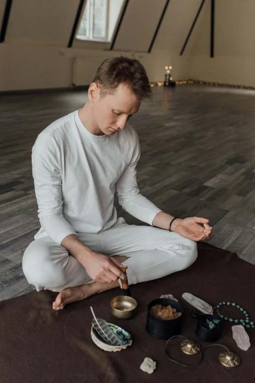 a man in a white shirt is sitting on a yoga mat, pexels contest winner, renaissance, smoking a bowl of hash together, health spa and meditation center, profile image, dasha taran