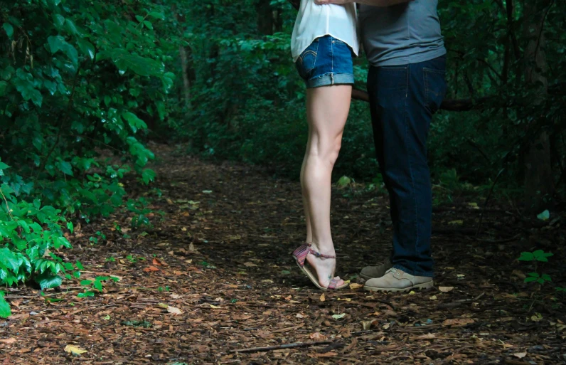 a man and a woman standing next to each other in the woods, an album cover, by Jan Rustem, pexels, legs intertwined, making out, low - lighting, taken in the late 2010s
