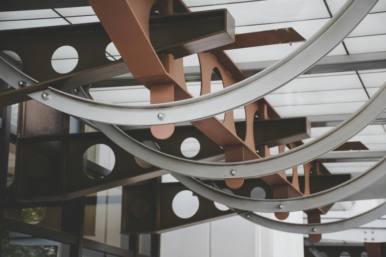 a clock hanging from the ceiling of a building, an abstract sculpture, inspired by János Nagy Balogh, unsplash, kinetic art, steel archways, ((rust)), low detail, awnings