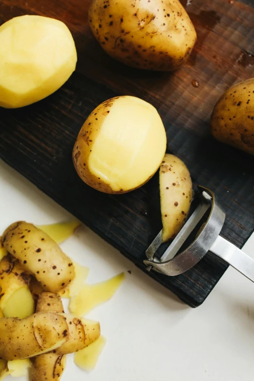 a cutting board with potatoes and a knife, valves, kailee mandel, scandinavian, sleek hands