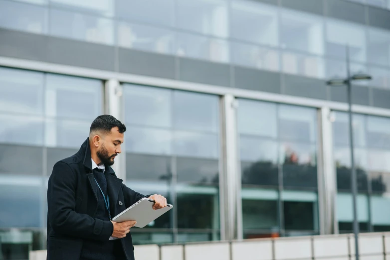 a man in a suit holding a tablet computer, unsplash, coventry city centre, khyzyl saleem, holding a clipboard, profile image