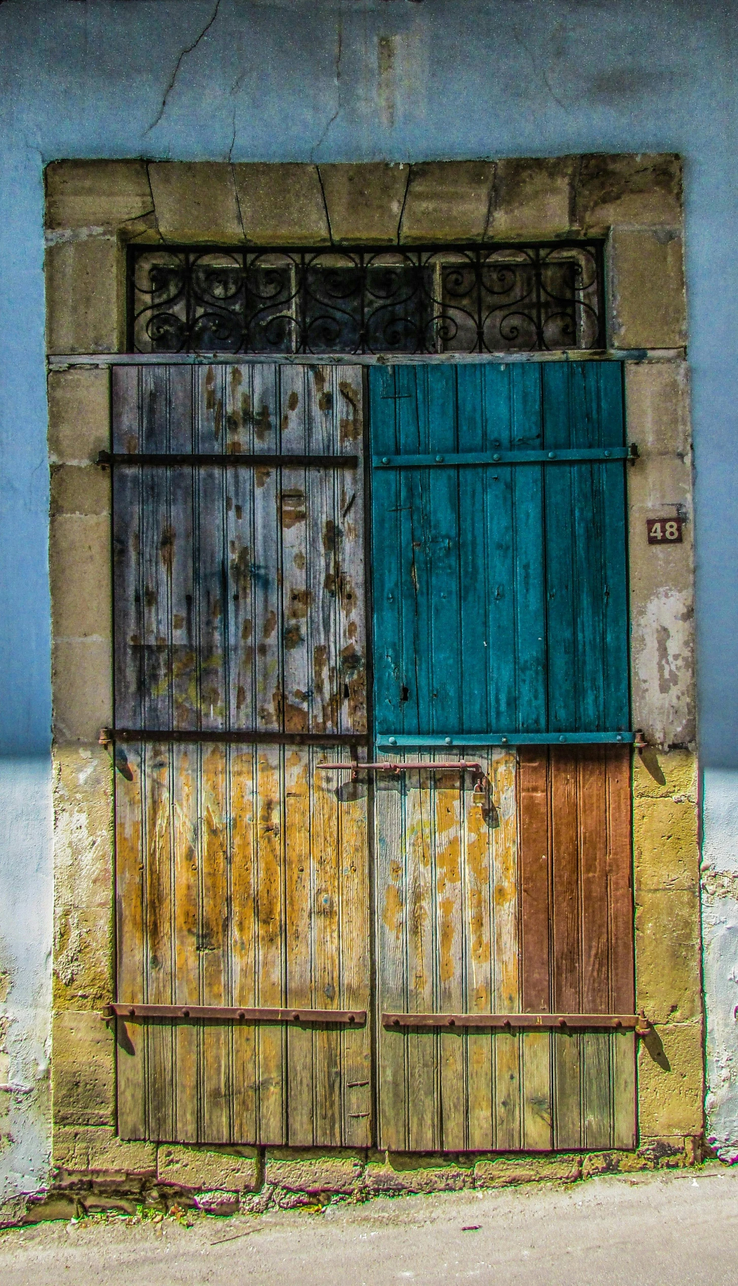 a motorcycle that is parked in front of a building, an album cover, by Peter Churcher, pexels contest winner, renaissance, iron gate door texture, multi colored, jerez, cyan shutters on windows