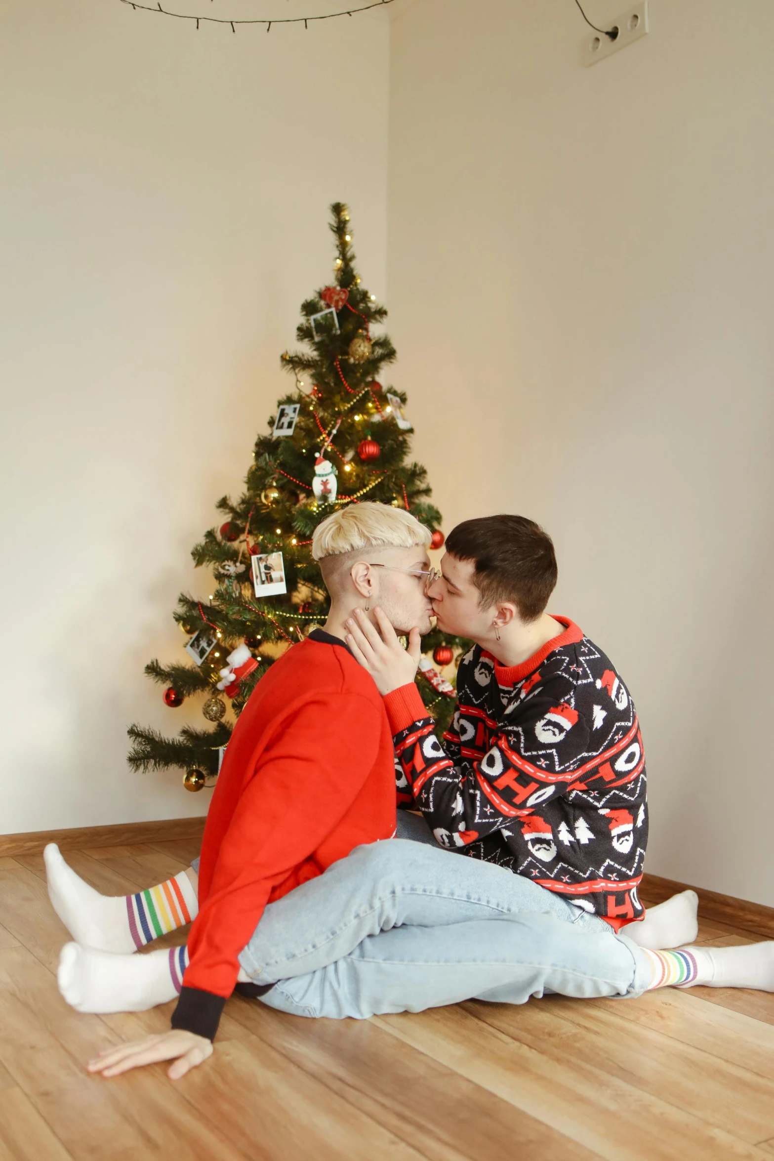 a man and woman sitting in front of a christmas tree, a photo, by Julia Pishtar, pexels, pop art, lesbian kiss, 15081959 21121991 01012000 4k, full shot photograph, boys