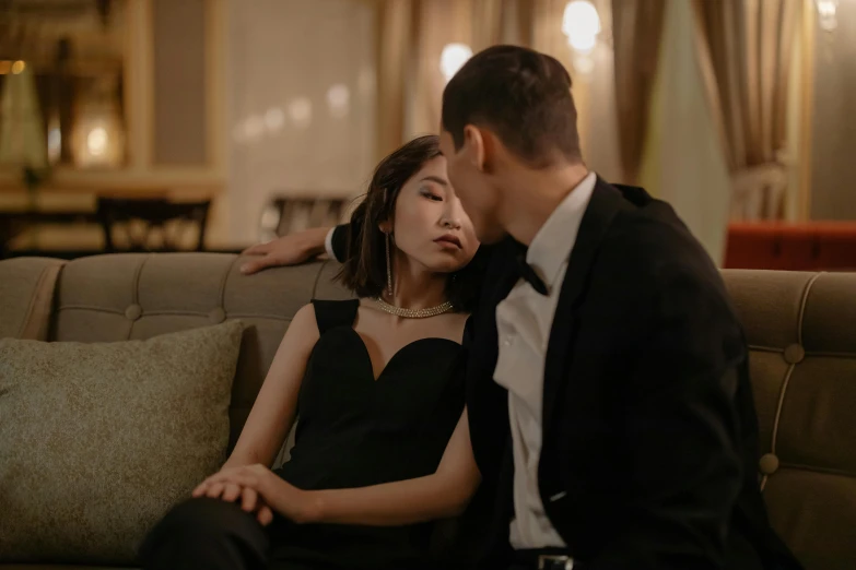 a man and a woman sitting on a couch, by Emma Andijewska, pexels contest winner, asian girl, black tie, making out, [ theatrical ]