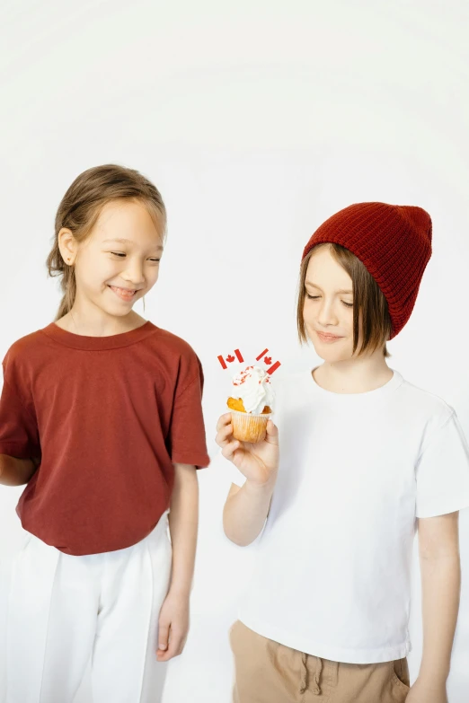 a couple of kids standing next to each other, by Nicolette Macnamara, shutterstock contest winner, antipodeans, cupcake, maple syrup, white and red color scheme, product design shot