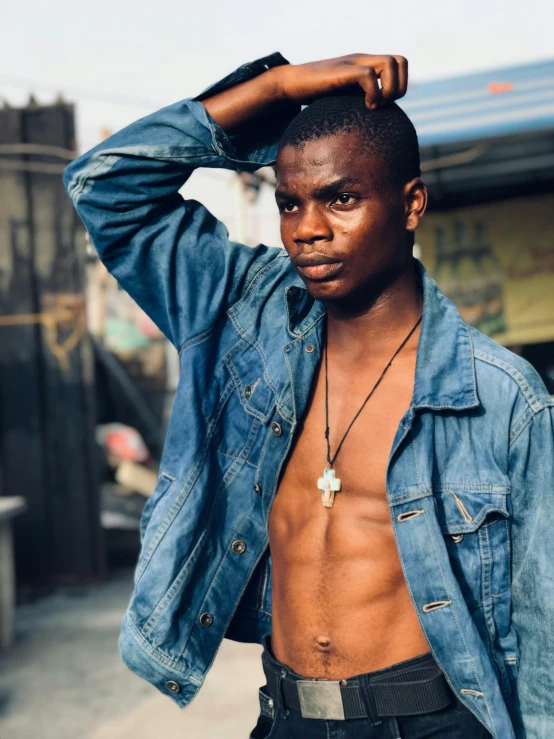 a shirtless man standing on a city street, an album cover, by Chinwe Chukwuogo-Roy, trending on unsplash, wearing a jeans jackets, non binary model, 15081959 21121991 01012000 4k, headshot