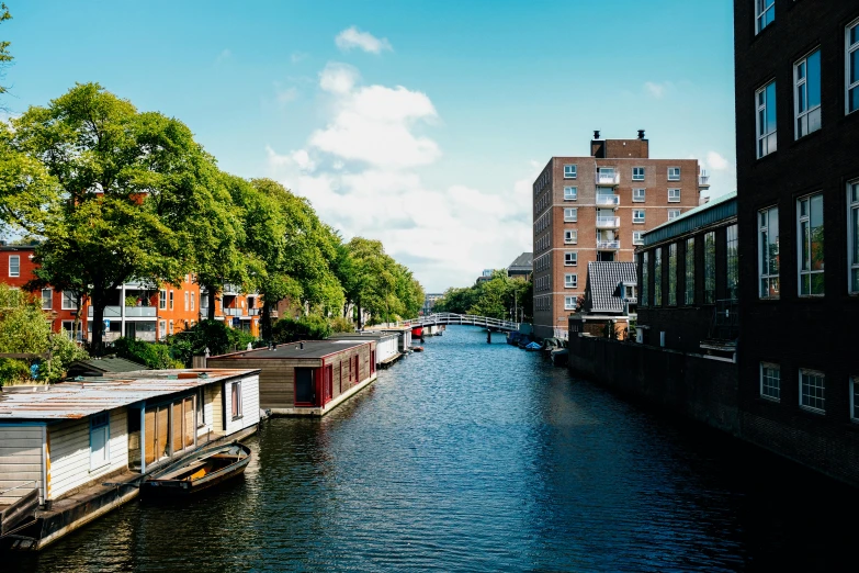 a river running through a city next to tall buildings, by Jan Tengnagel, unsplash, visual art, delft, bright sunny day, thumbnail, denmark