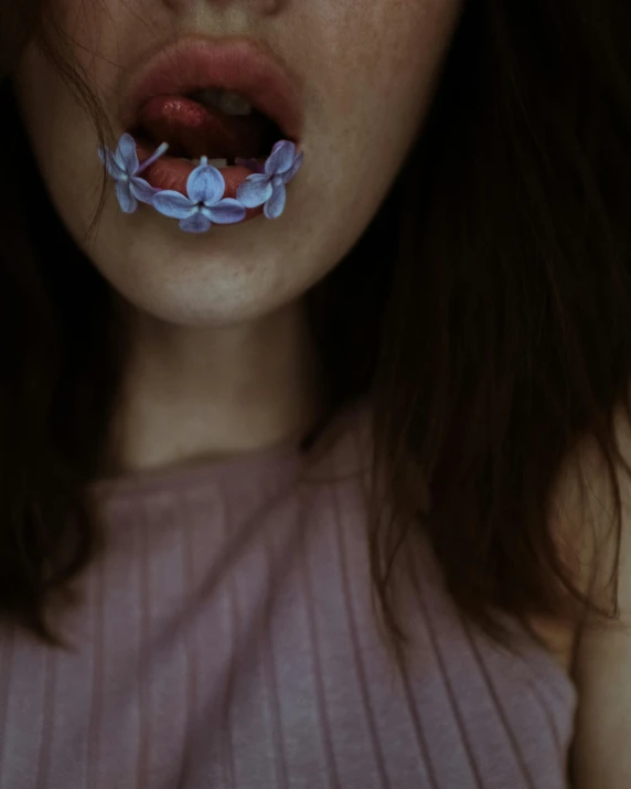 a close up of a person with a toothbrush in their mouth, a colorized photo, inspired by Elsa Bleda, trending on pexels, aestheticism, ribbons and flowers, wearing a crop top, blue - petals, gothic aesthetic