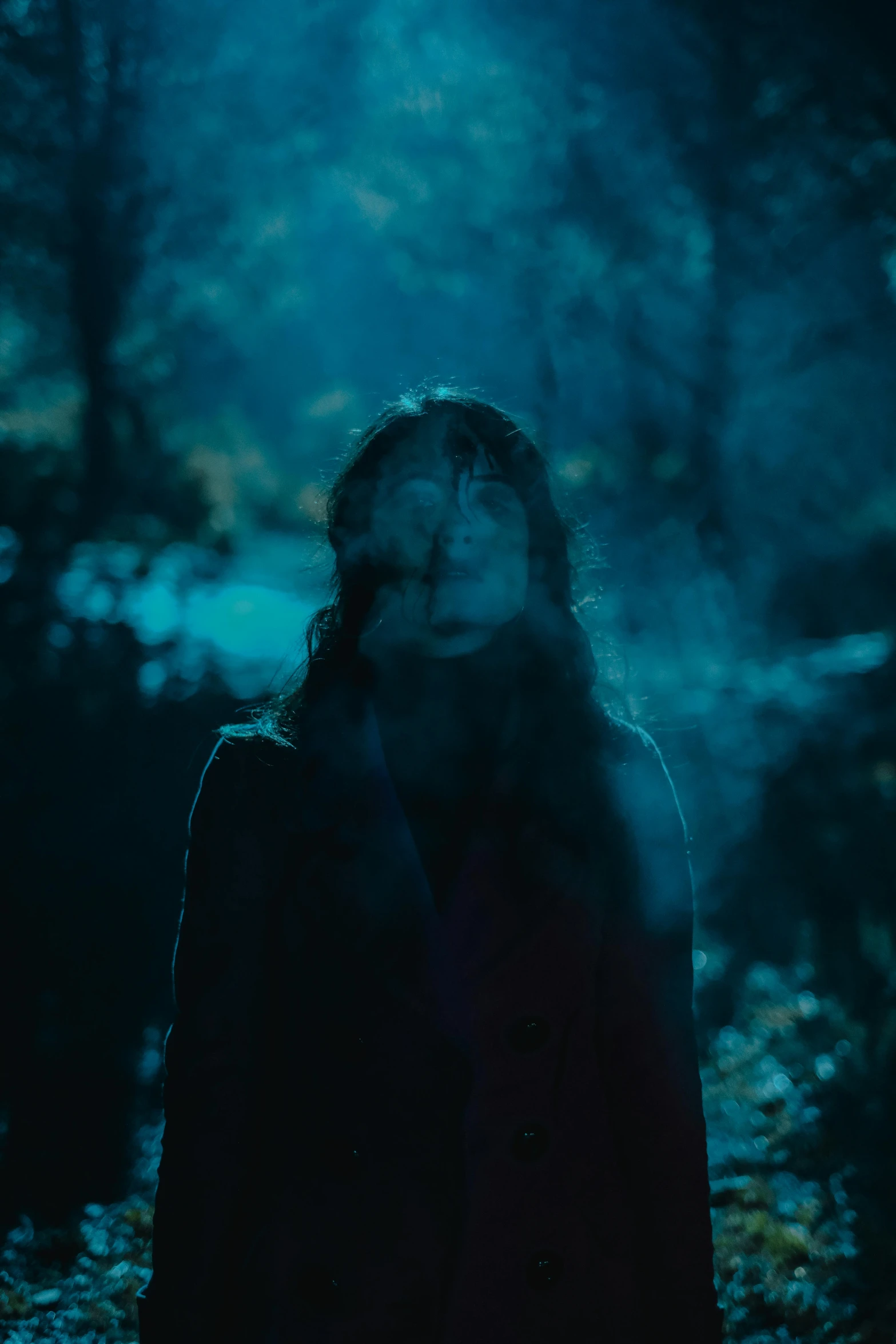 a woman standing in the middle of a forest at night, an album cover, pexels contest winner, blue haze, movie still frame, portait photo, concert