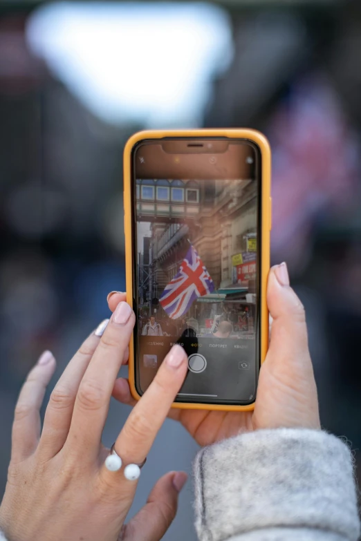 a close up of a person holding a cell phone, a picture, union jack, multiple stories, transparent