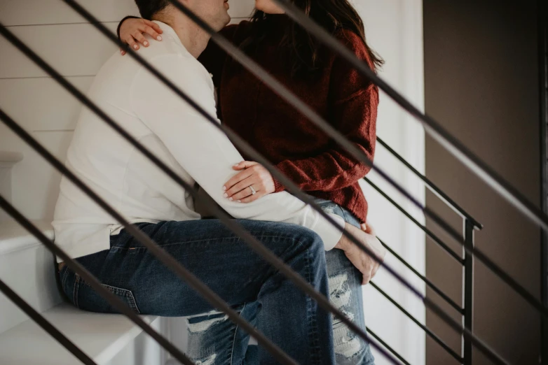 a couple of people that are sitting on some stairs, a picture, by Emma Andijewska, trending on pexels, romanticism, making out, thighs close up, background image, indoor picture