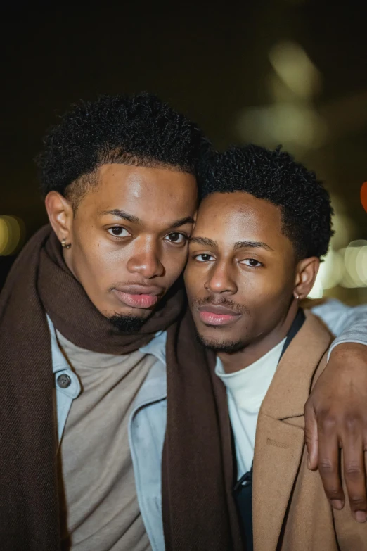 a couple of men standing next to each other, by Stokely Webster, embracing, trending photo, press photos, androgynous person