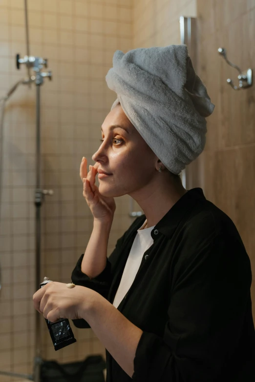 a woman with a towel on her head brushing her teeth, by Matija Jama, pexels, renaissance, elegant profile pose, androgynous face, evening time, without makeup