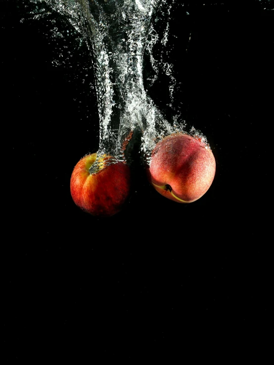 two apples falling into the water on a black background, by Matthias Stom, pexels, 2 5 6 x 2 5 6 pixels, peaches, concert, behind the scenes