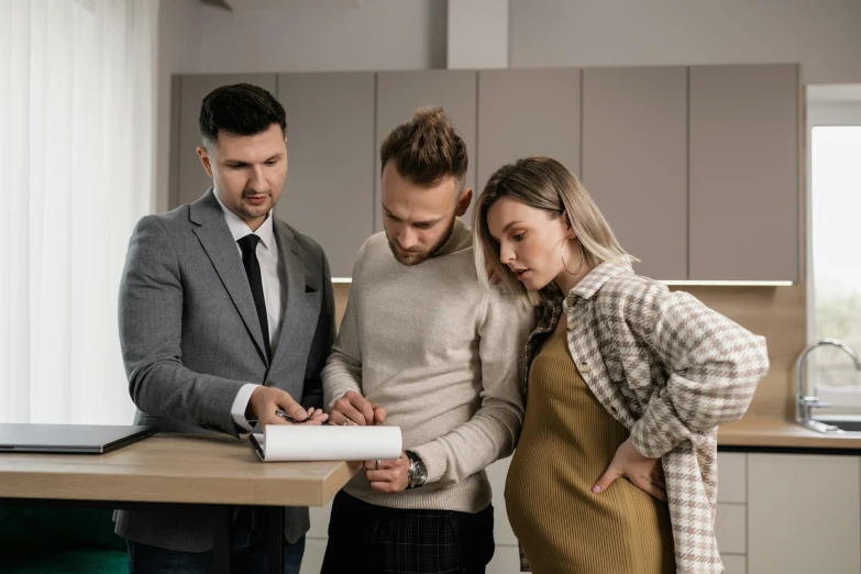 a man and a woman looking at a piece of paper, pregnant, architectural planning, selling insurance, brown