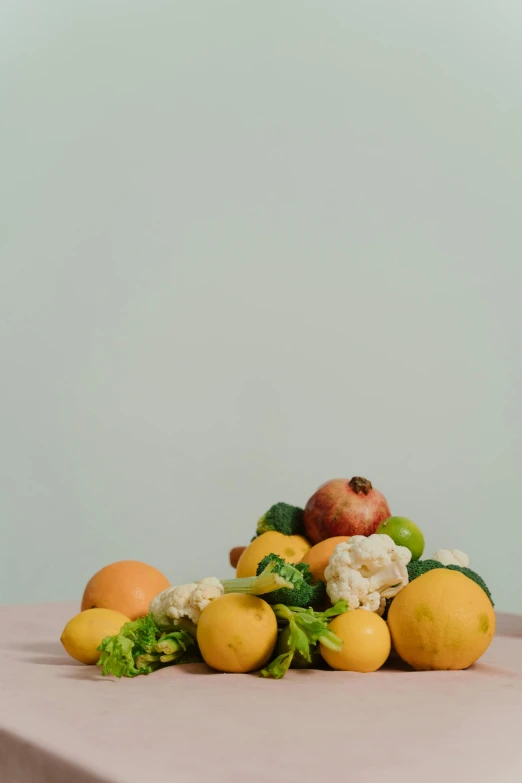 a pile of fruit and vegetables sitting on a table, by Carey Morris, on a pale background, lemon, centered shot