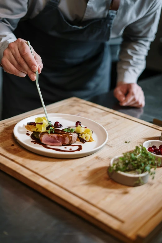 a man is preparing a meal on a cutting board, by Andries Stock, pexels contest winner, renaissance, served on a plate, duck, fancy dressing, australian