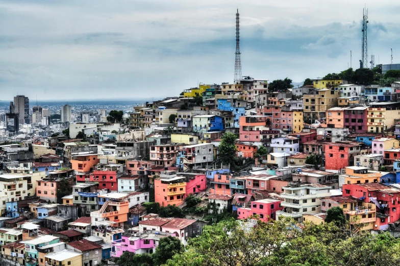 a city filled with lots of colorful buildings, a colorized photo, by Tom Wänerstrand, pexels contest winner, quito school, colourful jungle, profile image, hillside, sparsely populated