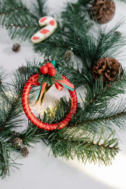 a close up of a christmas wreath on a table, organic ornament, miko, medium, hoop earrings