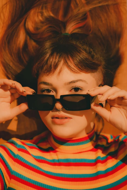 a woman laying on top of a wooden floor wearing sunglasses, trending on pexels, visual art, joey king, pictured from the shoulders up, multicoloured, portrait sophie mudd